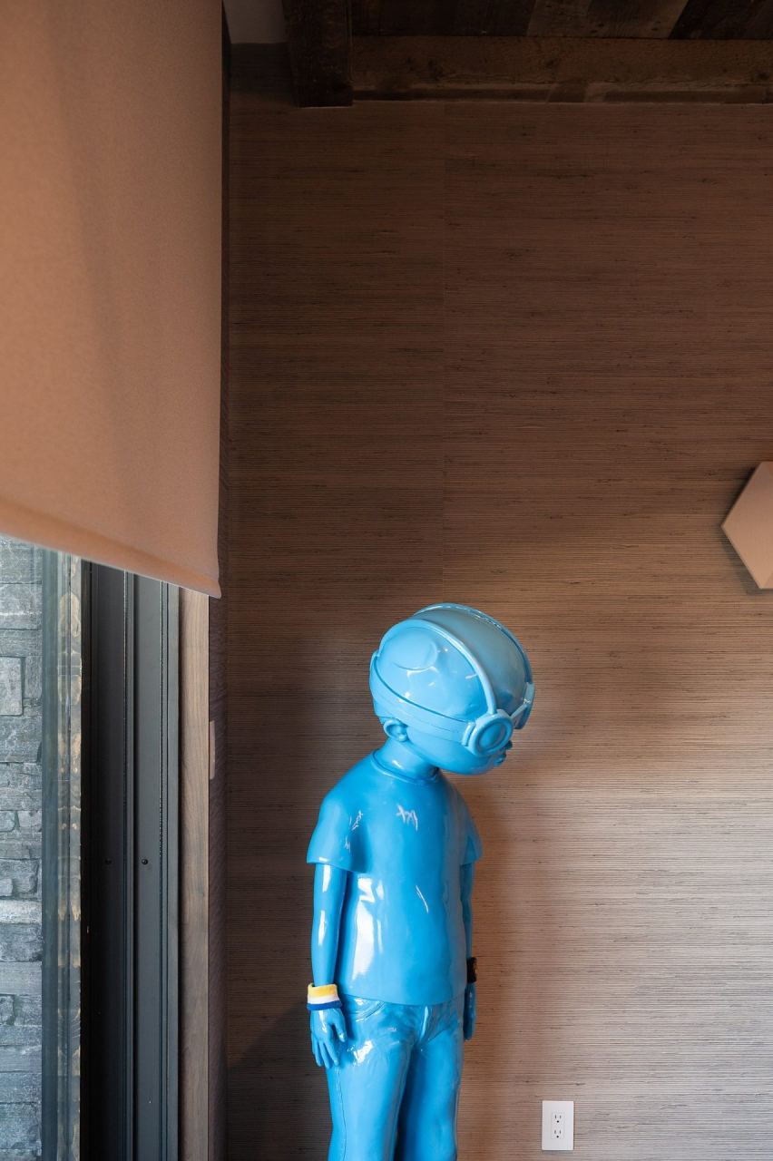 Blue figural sculpture by a sun-shaded picture window &mdash; Park City home by Techi
