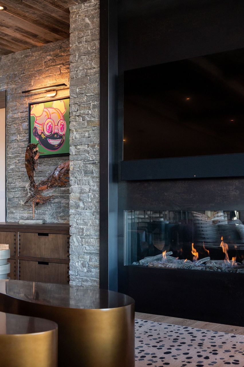 The Colony stone fireplace with mounted hex art panel in a great room