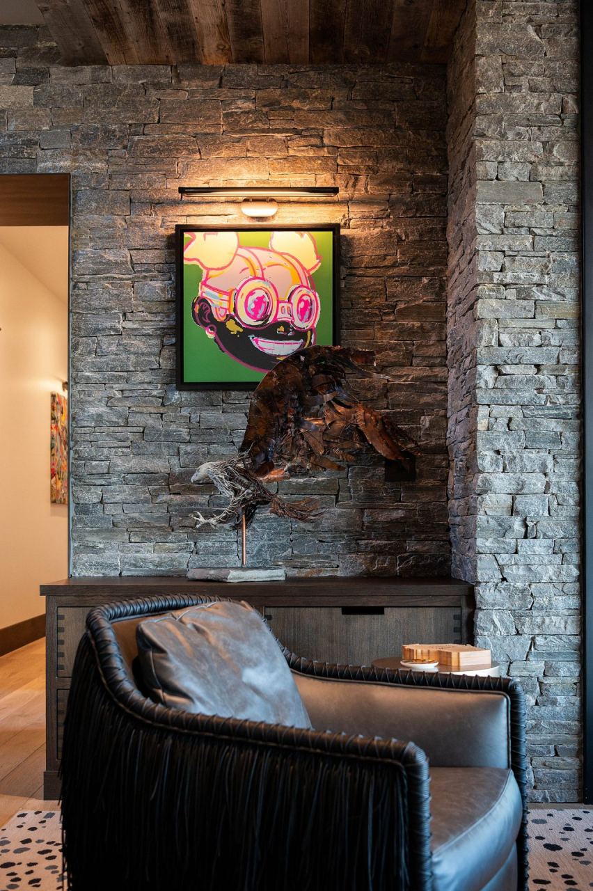 Stone wall with green cartoon art and metal bird sculpture &mdash; Park City home by Techi