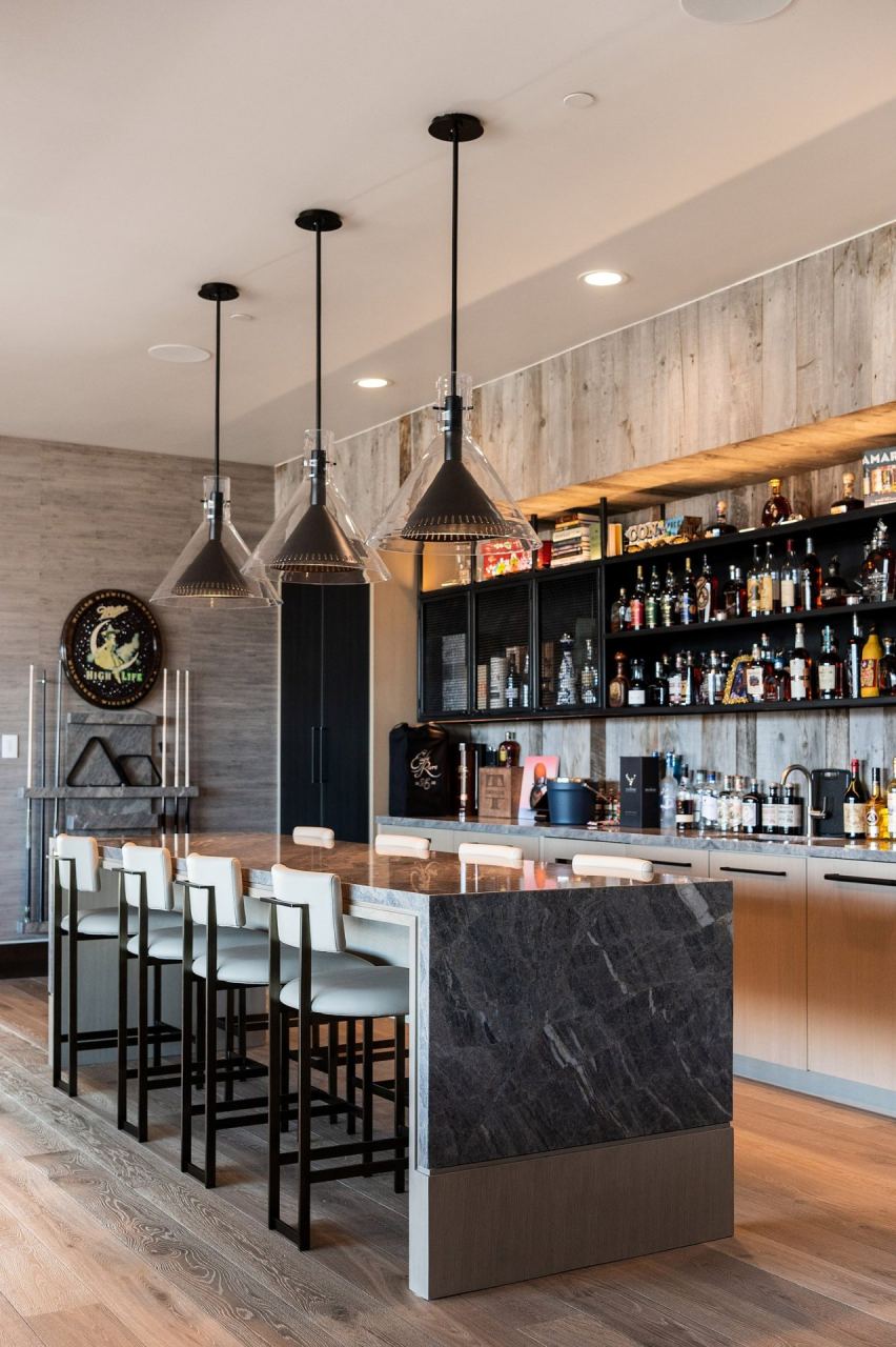 Home bar with pendant lighting and stocked back-bar &mdash; Park City home by Techi