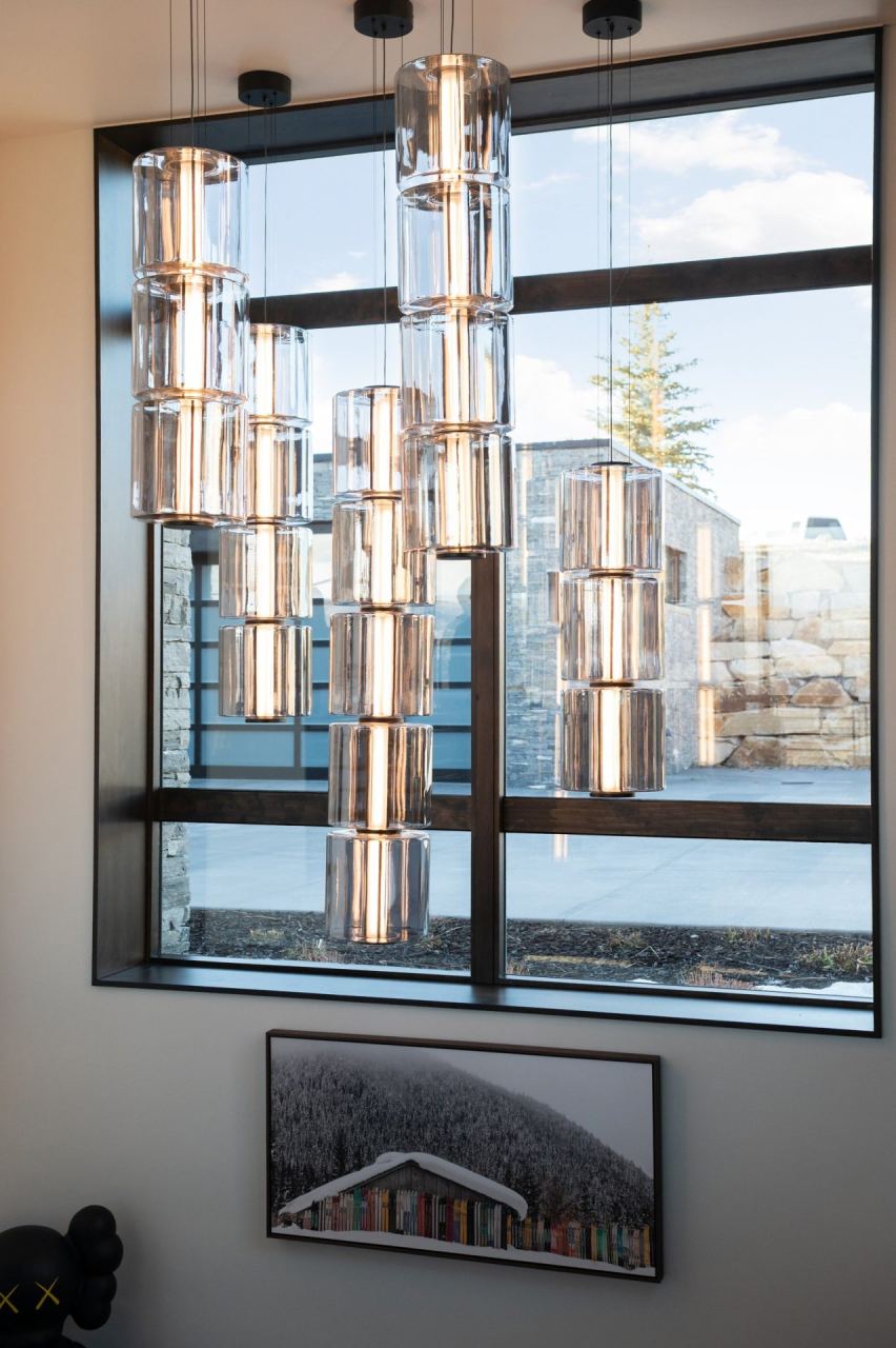 Floor-to-ceiling window chandelier with mountain backdrop &mdash; Park City home by Techi
