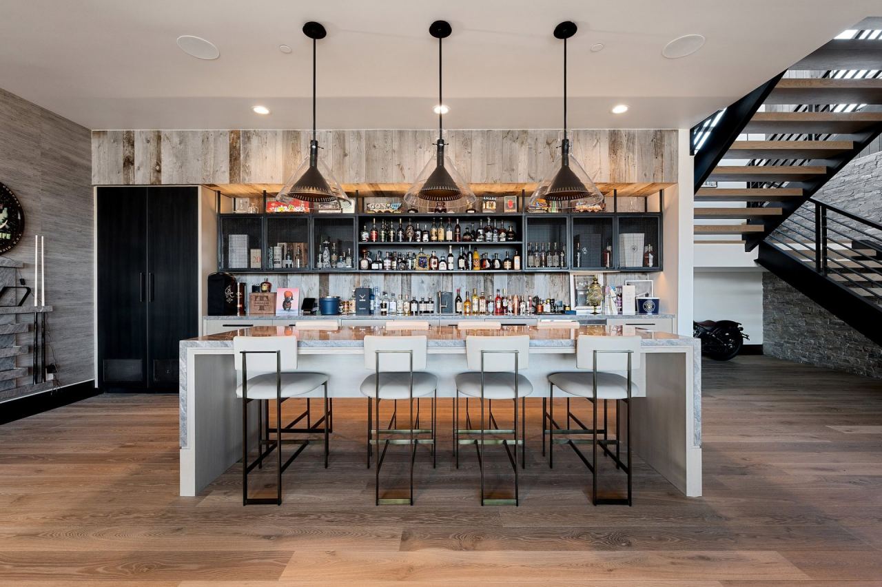 Long island bar with bottle wall and warm pendants &mdash; Park City home by Techi
